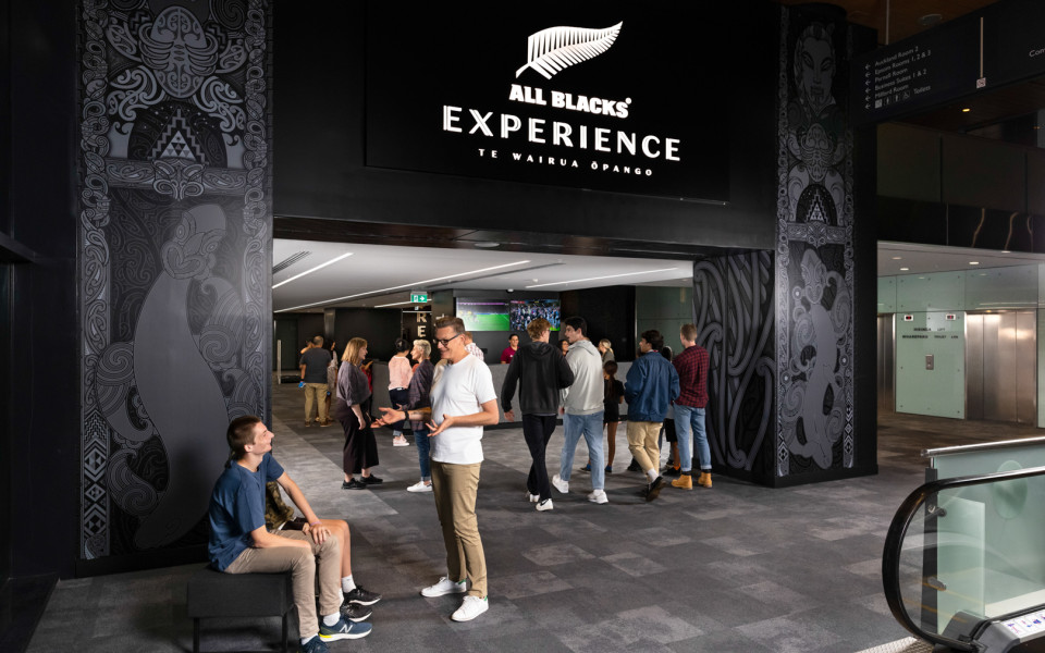 Man standing in front of the entrance to the All Blacks Experience 
