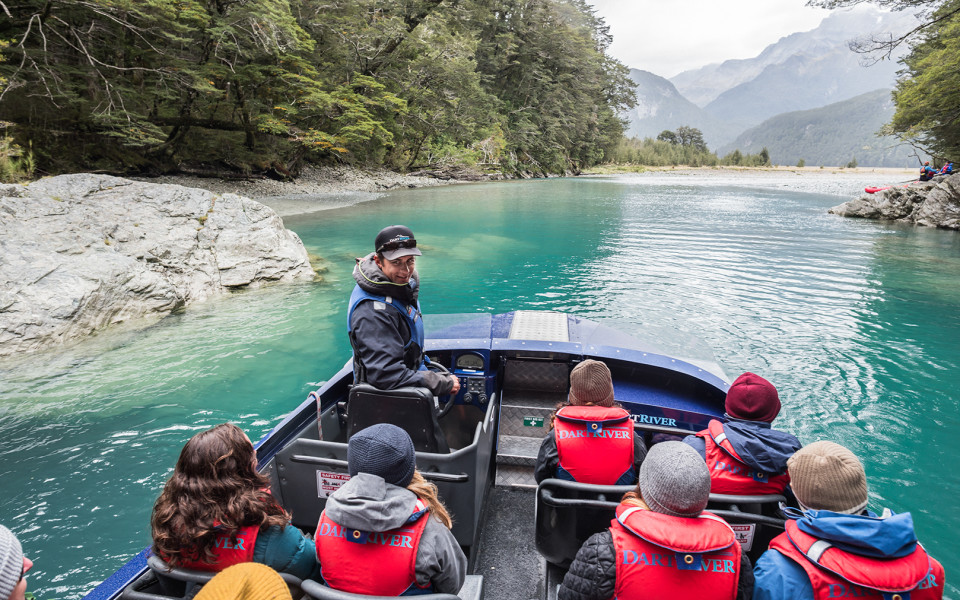 Jet Boat Driver talking to passengers on boat with beautiful river in the background