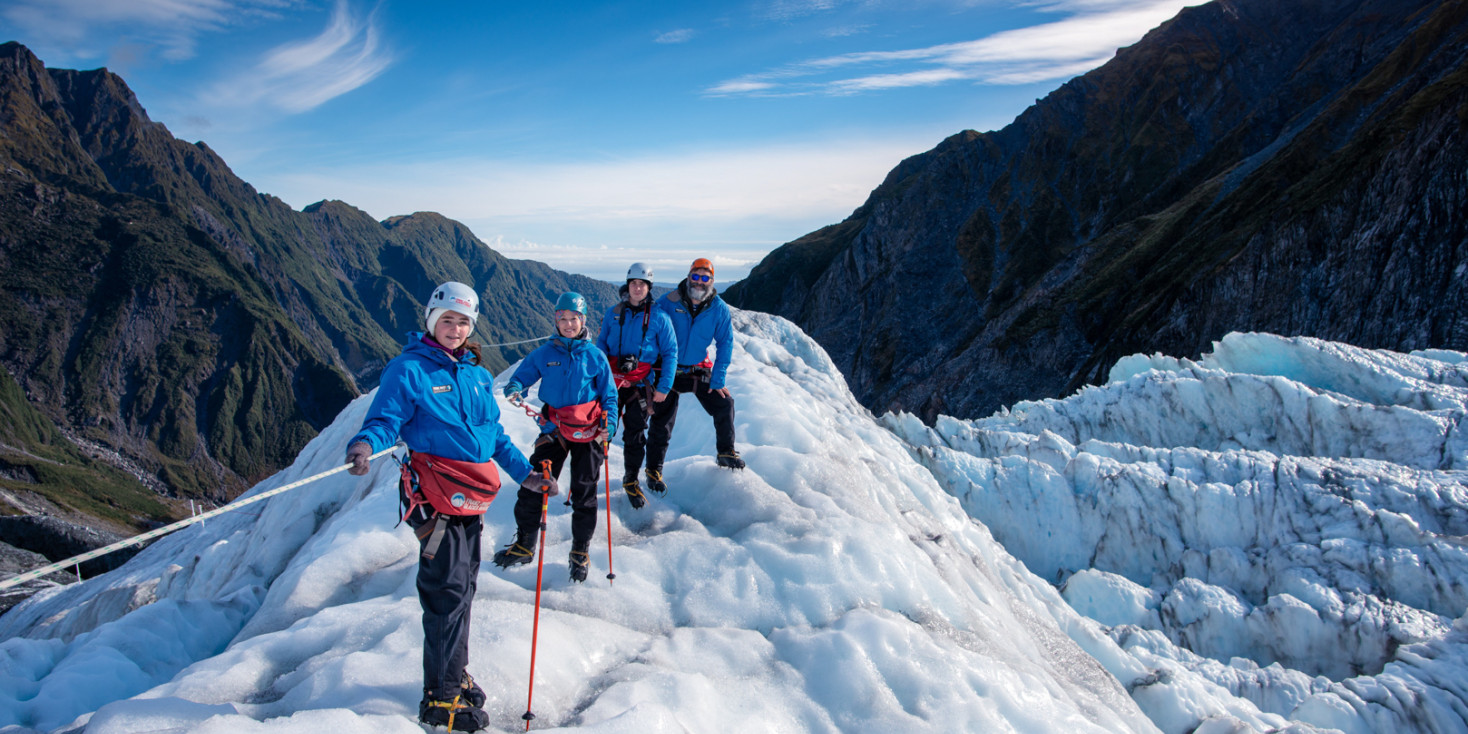 Group of people standing on glacier with view down the valley