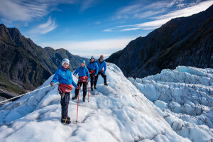 Group of people standing on glacier with view down the valley