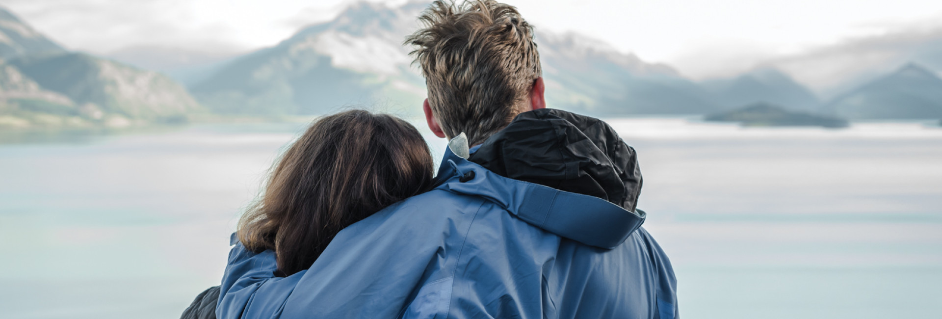 Couple embracing overlooking alpine river