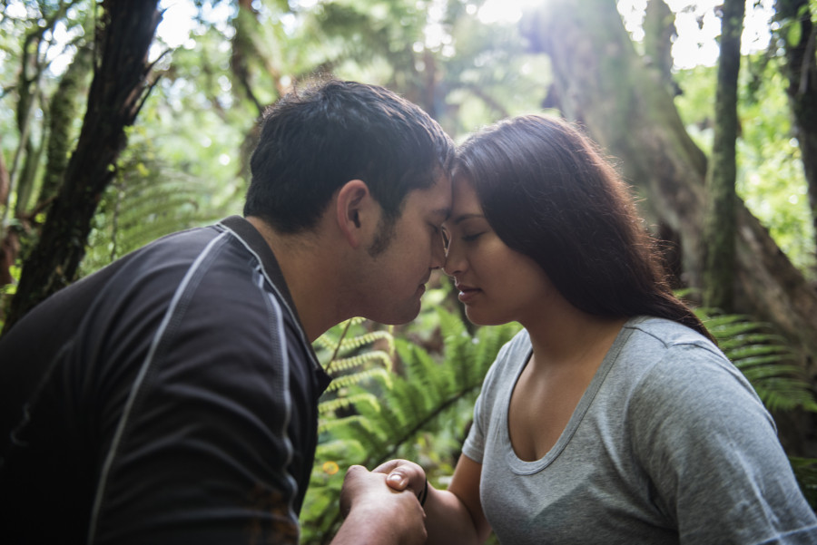 Man and woman presses noses in traditional maori hongi