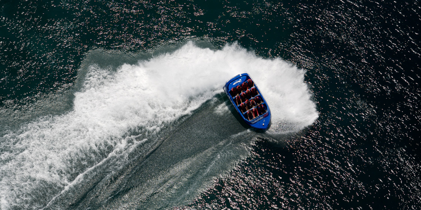 Aerial shot of jetboat doing a spin in river