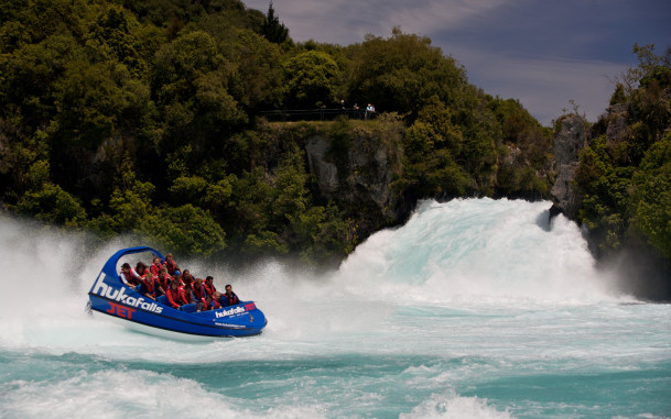 Jet boat doing a spin amongst the white water of powerful waterfall