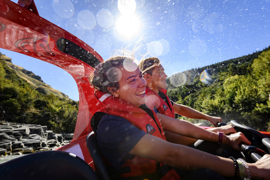 Two passengers holding on tight during a jet boat spin