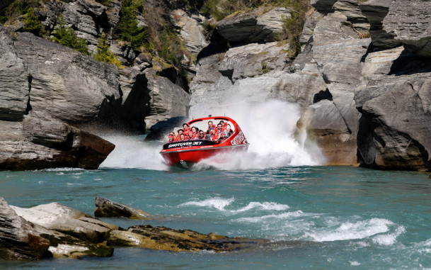 Jetboat racing through the narrow rocky shotover canyon