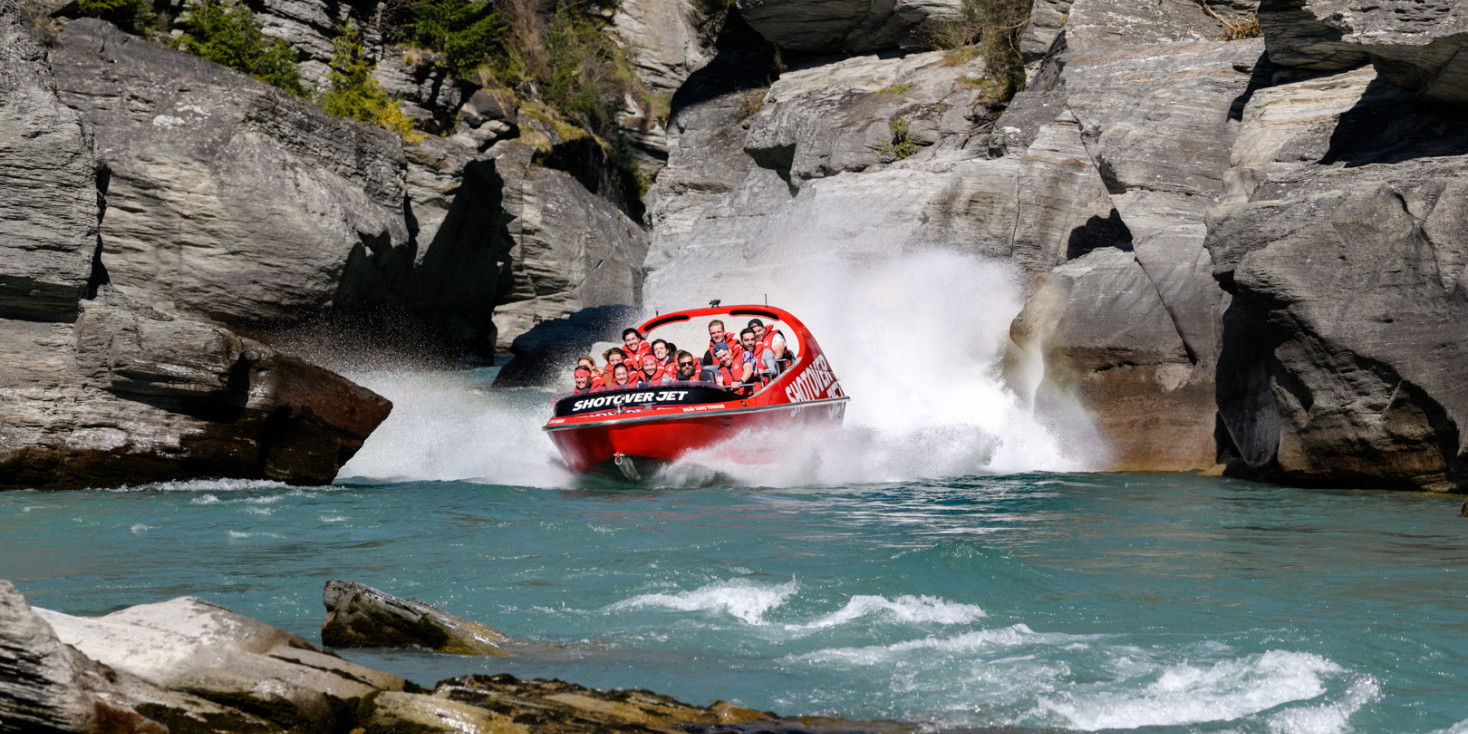 Jetboat racing through the narrow rocky shotover canyon
